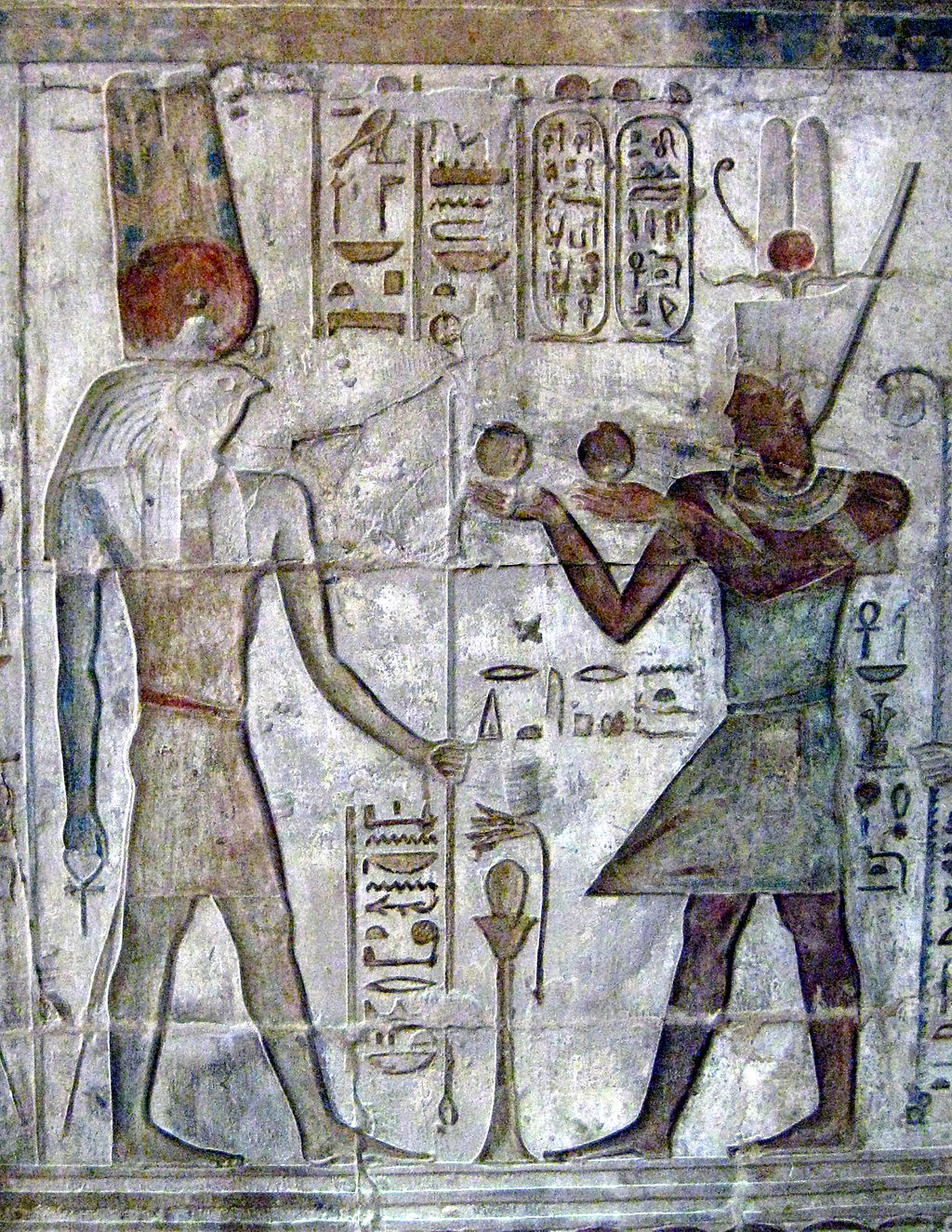 IV. Ptolemaiosz áldozatot mutat be Montunak (Kr. e. 222-204). Montu eredetleg Ré pusztító erejét személyesítette meg, és gyakran Montu-Ré néven emlegették, később azonban önállósult.